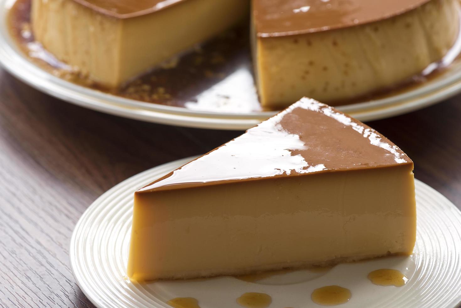 Homemade caramel custard pudding on a white plate on a wooden table photo