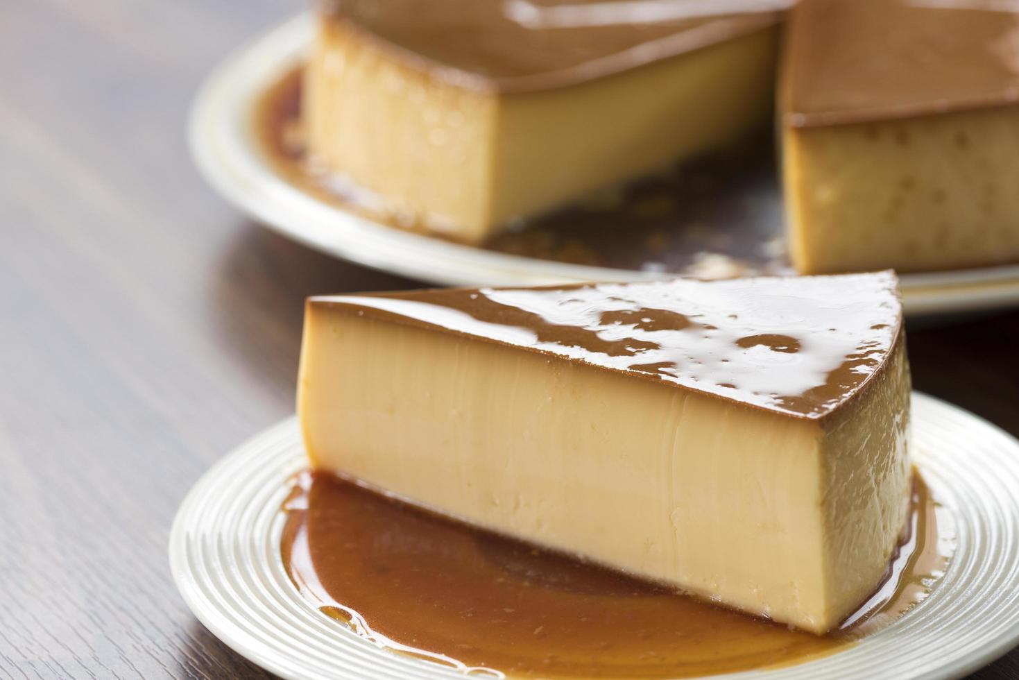 Flan de caramelo casero en una placa blanca sobre una mesa de madera foto