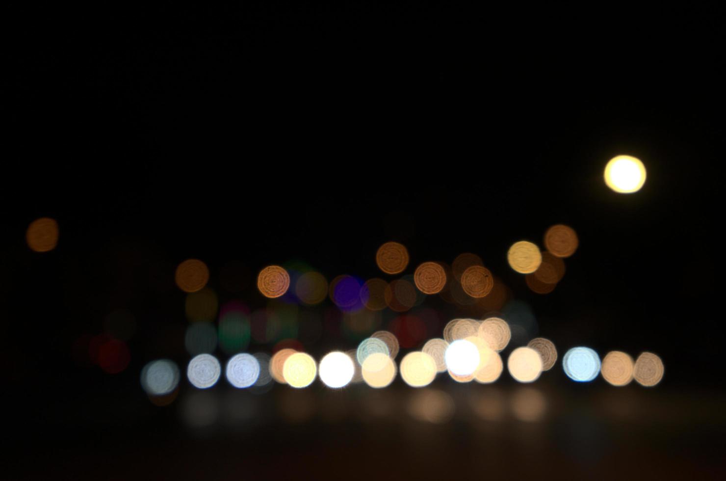 Blurry floating bokeh combination of cars on the road and street lights at the intersection photo