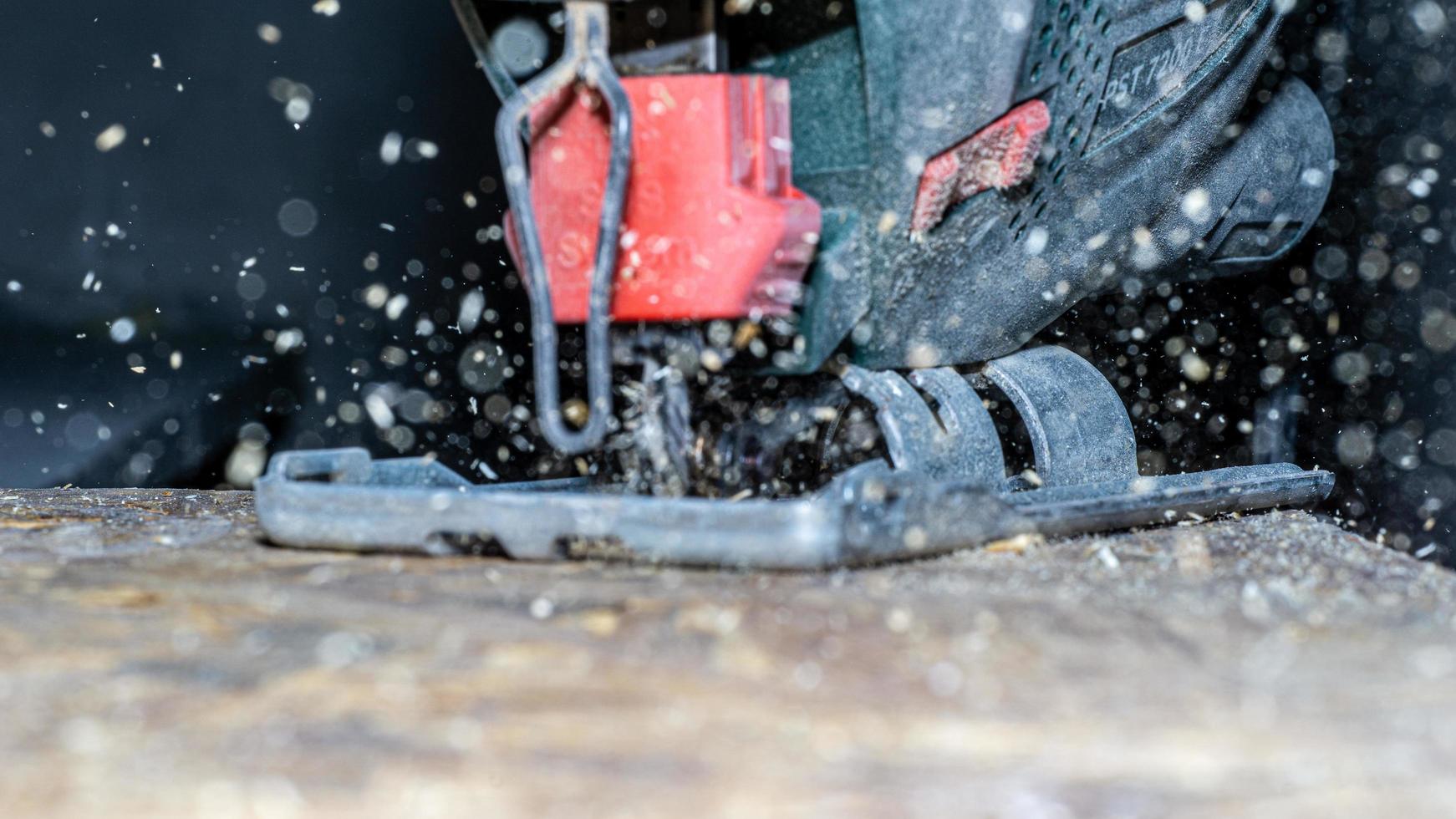 Close up of electric jigsaw cutting a piece of wood photo