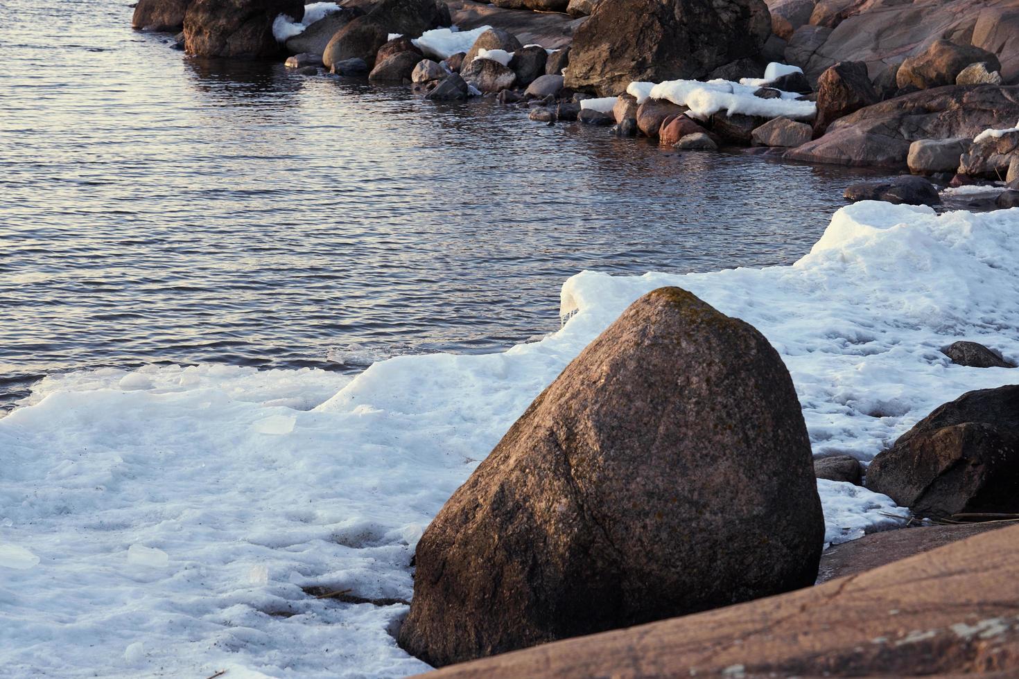 Icy seashore with rocks photo