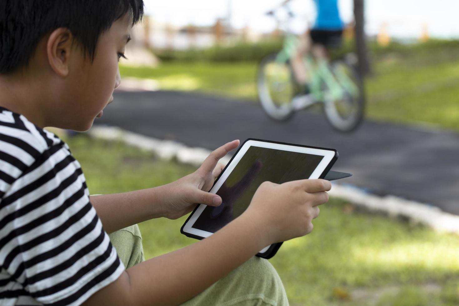 Boy using a tablet outside photo