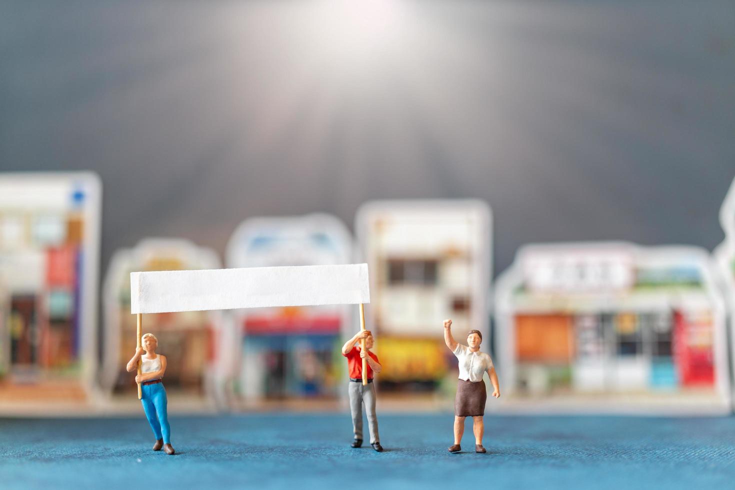 gente en miniatura, manifestantes sosteniendo carteles, levantando sus manos para la revolución, protestando concepto foto