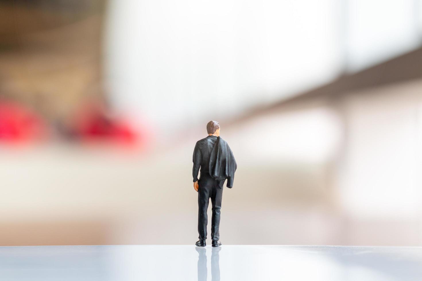 Miniature businessman standing on empty space for text photo