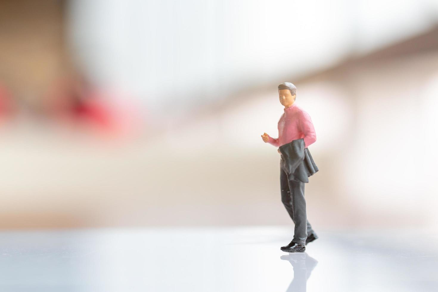 Miniature businessman standing on empty space for text photo