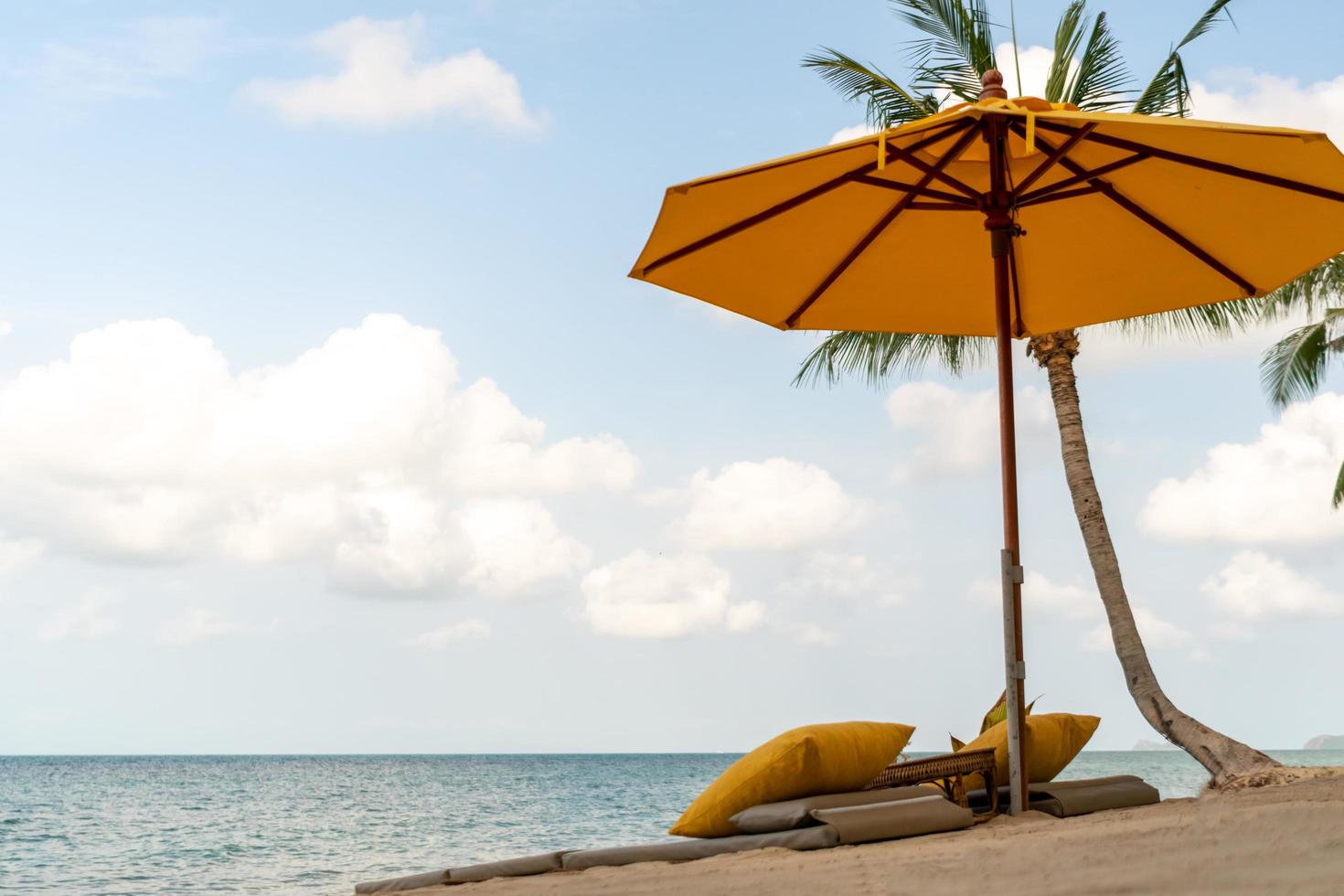 Umbrella and chair at a tropical summer beach background with copy space blue sky photo