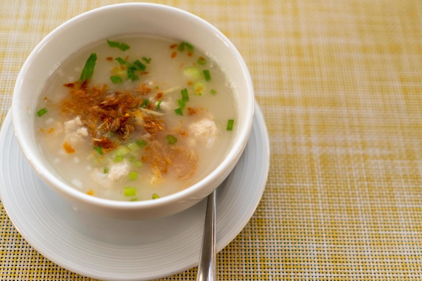 Thai-style breakfast pork rice soup with egg on a wooden table photo