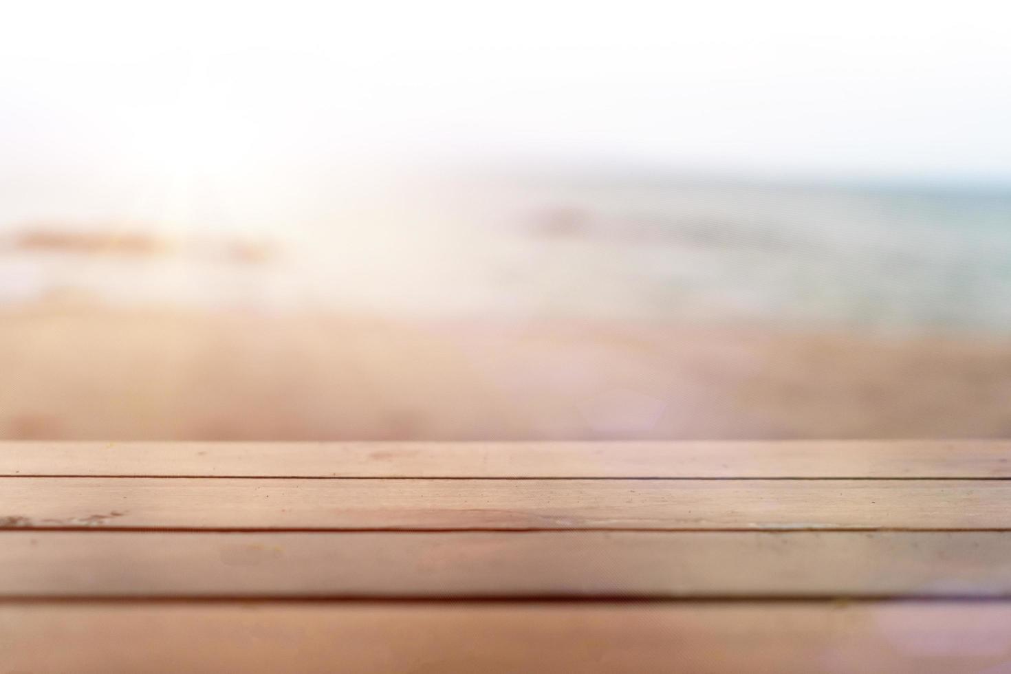 El enfoque selectivo de la mesa de madera vieja con desenfoque de fondo de playa hermosa para mostrar foto