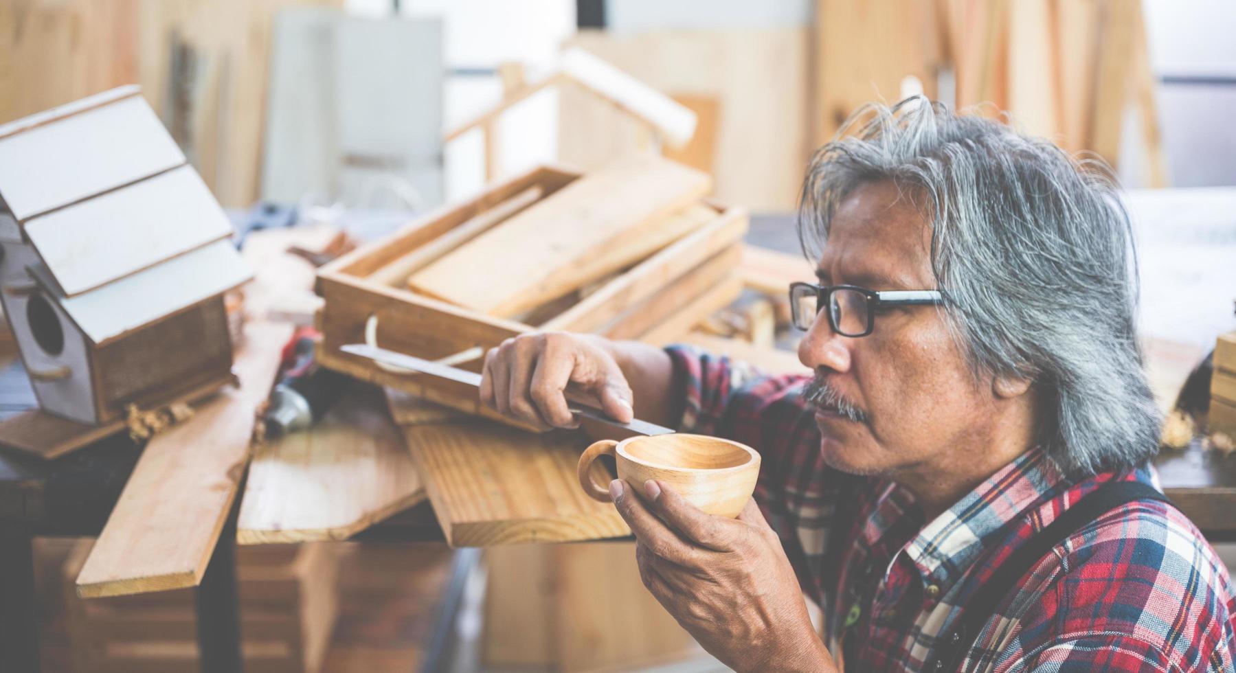 hombre haciendo una taza de madera foto