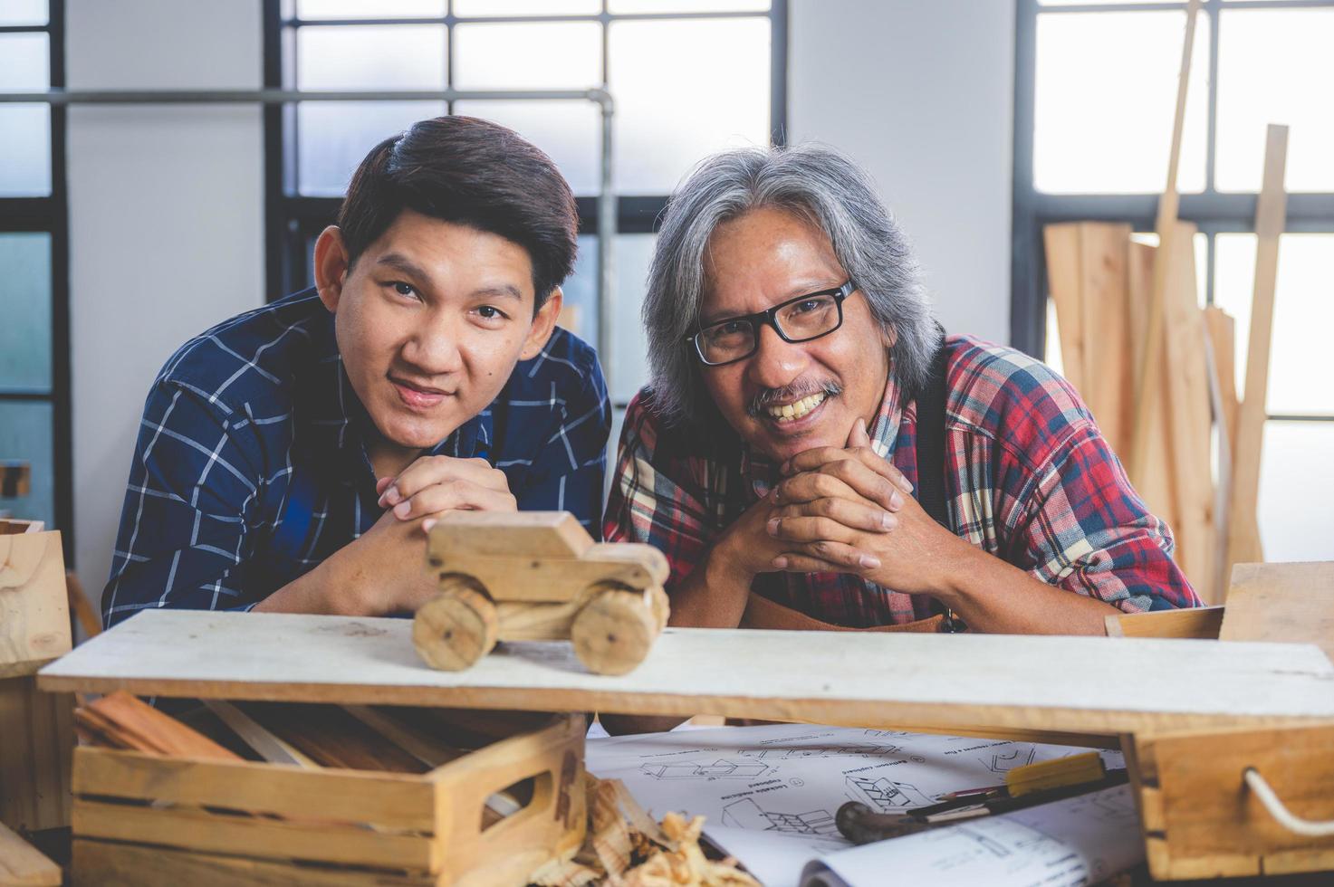 Two carpenters with a wooden car photo