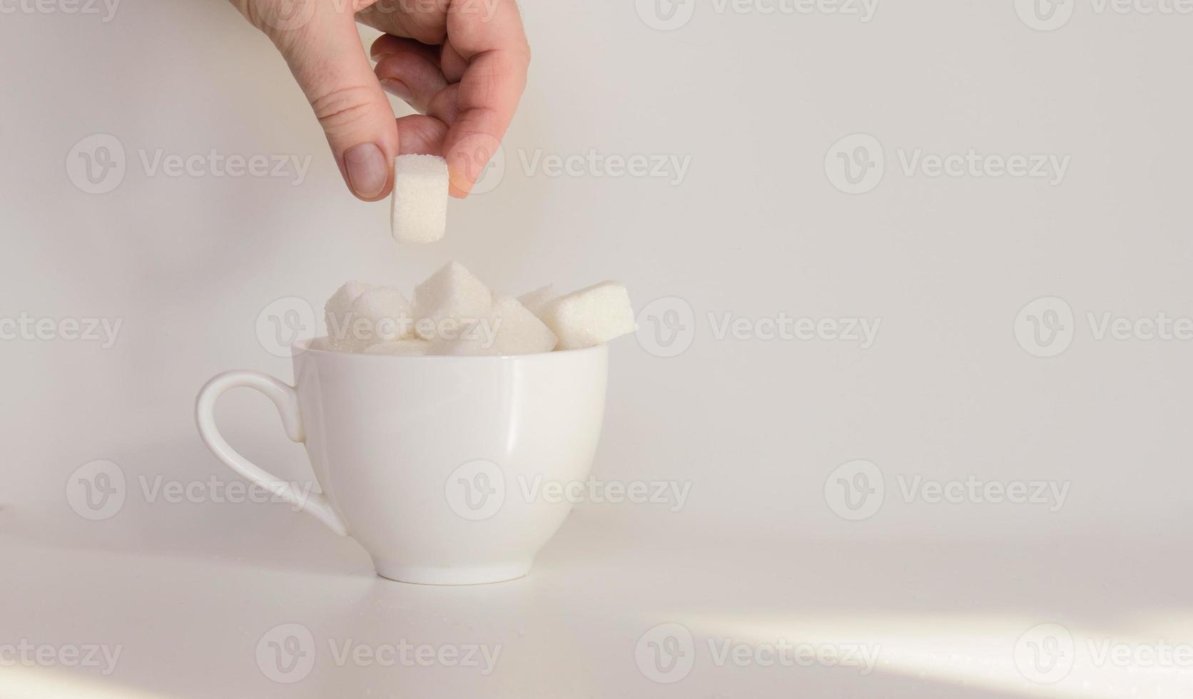 A coffee cup filled with lump sugar photo