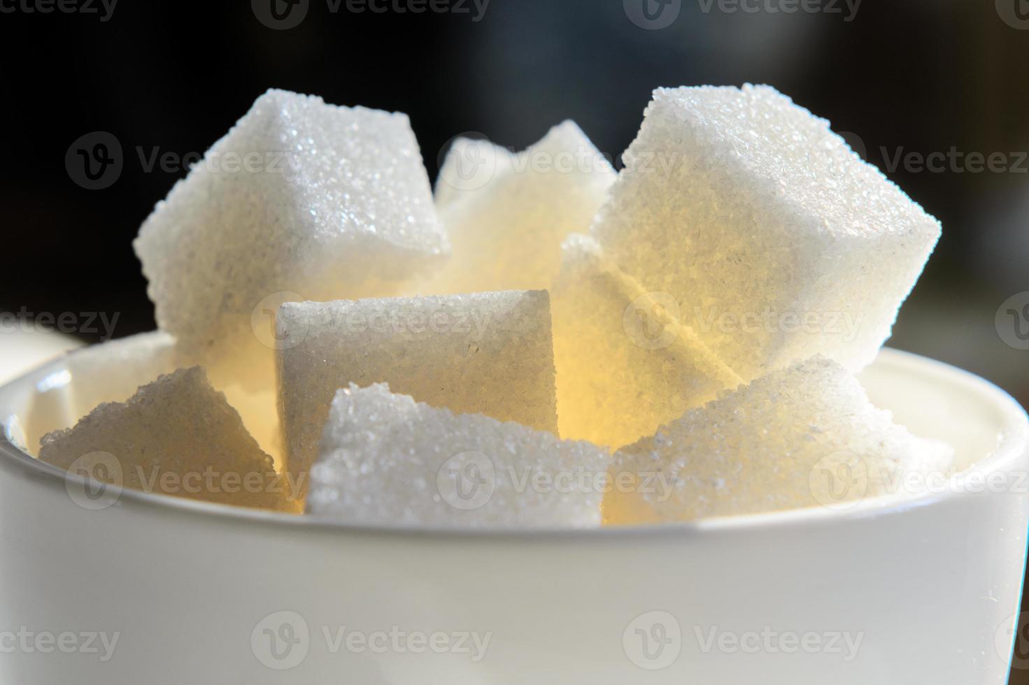 una taza blanca llena hasta el borde con terrones de azúcar foto