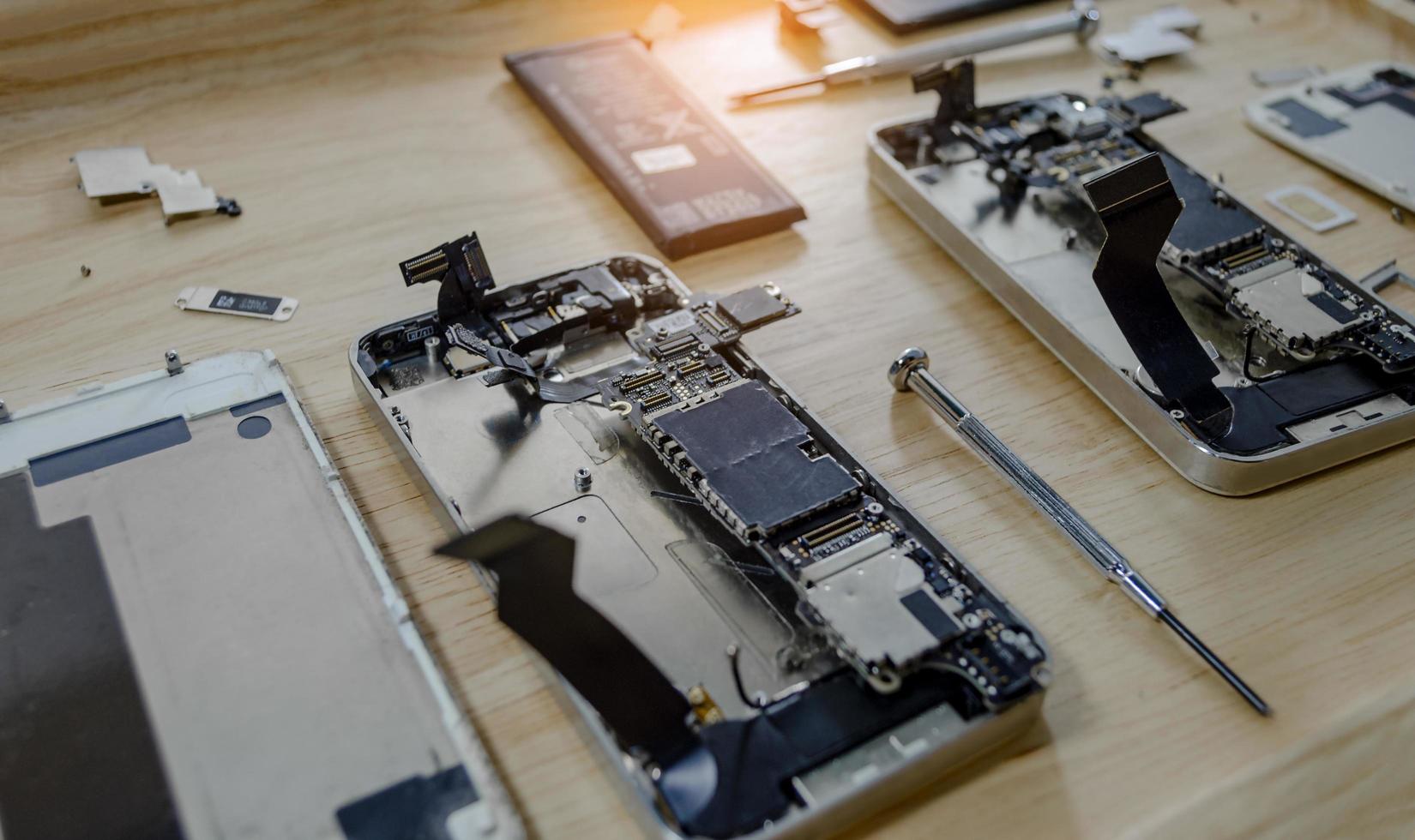 Smartphone motherboard repair by a professional technician on a desk photo