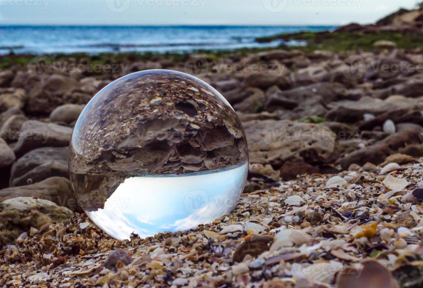 Glass lens ball on rocks photo