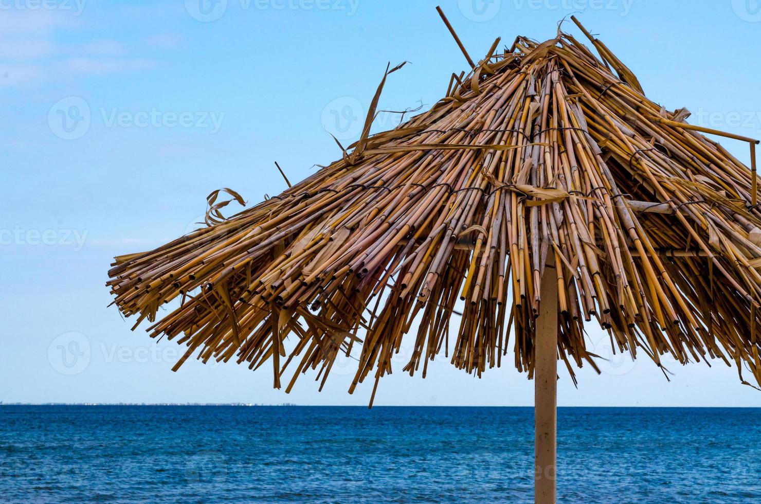 Straw umbrella on a beach photo