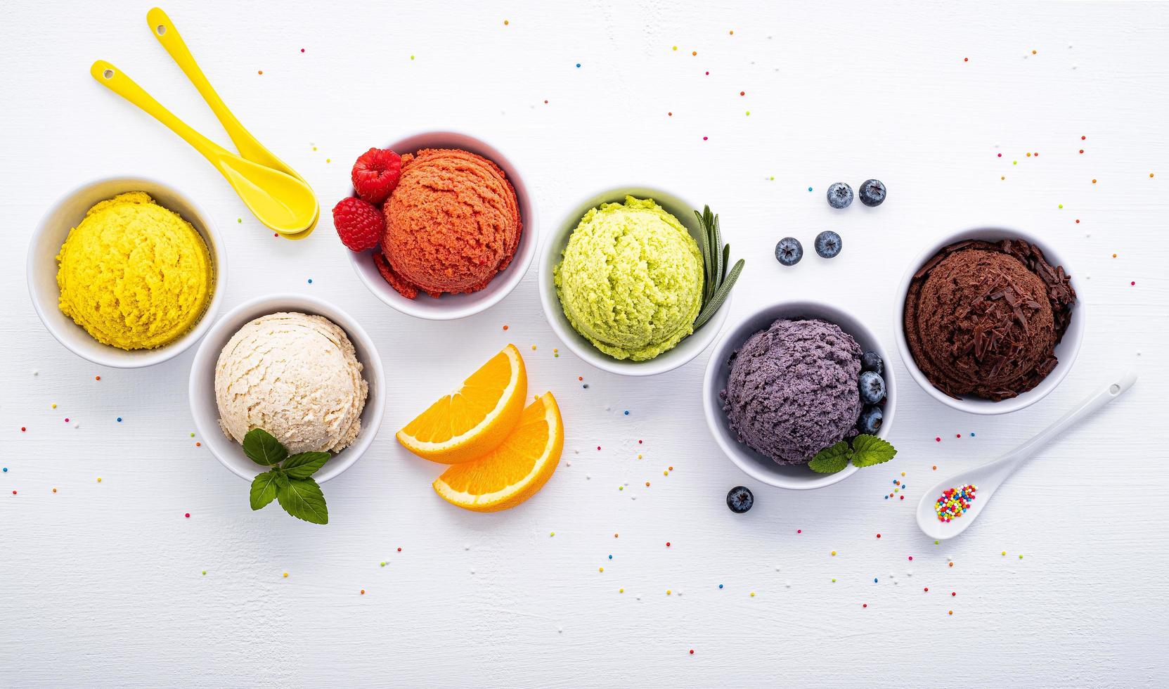 Varias bolas de sabor a helado sobre un fondo de madera blanca. concepto de menú de verano y dulces. foto