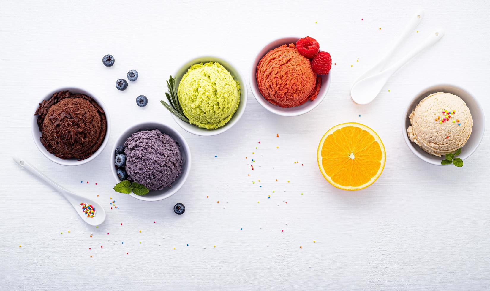 Various ice cream flavor balls on a white wooden background. Summer and sweets menu concept. photo