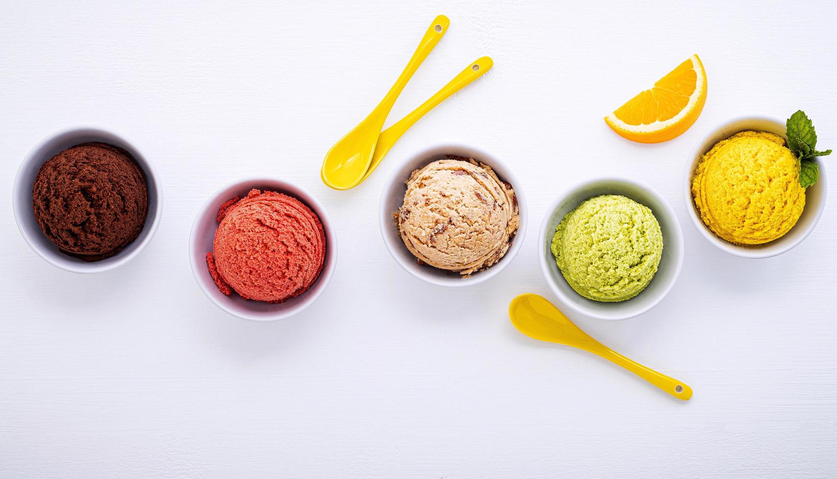 Varias bolas de sabor a helado sobre un fondo de madera blanca. concepto de menú de verano y dulces. foto