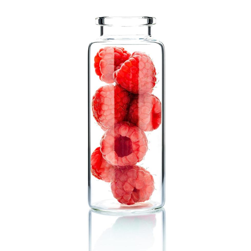 Homemade skin care with raspberries in a glass bottle isolated on a white background photo