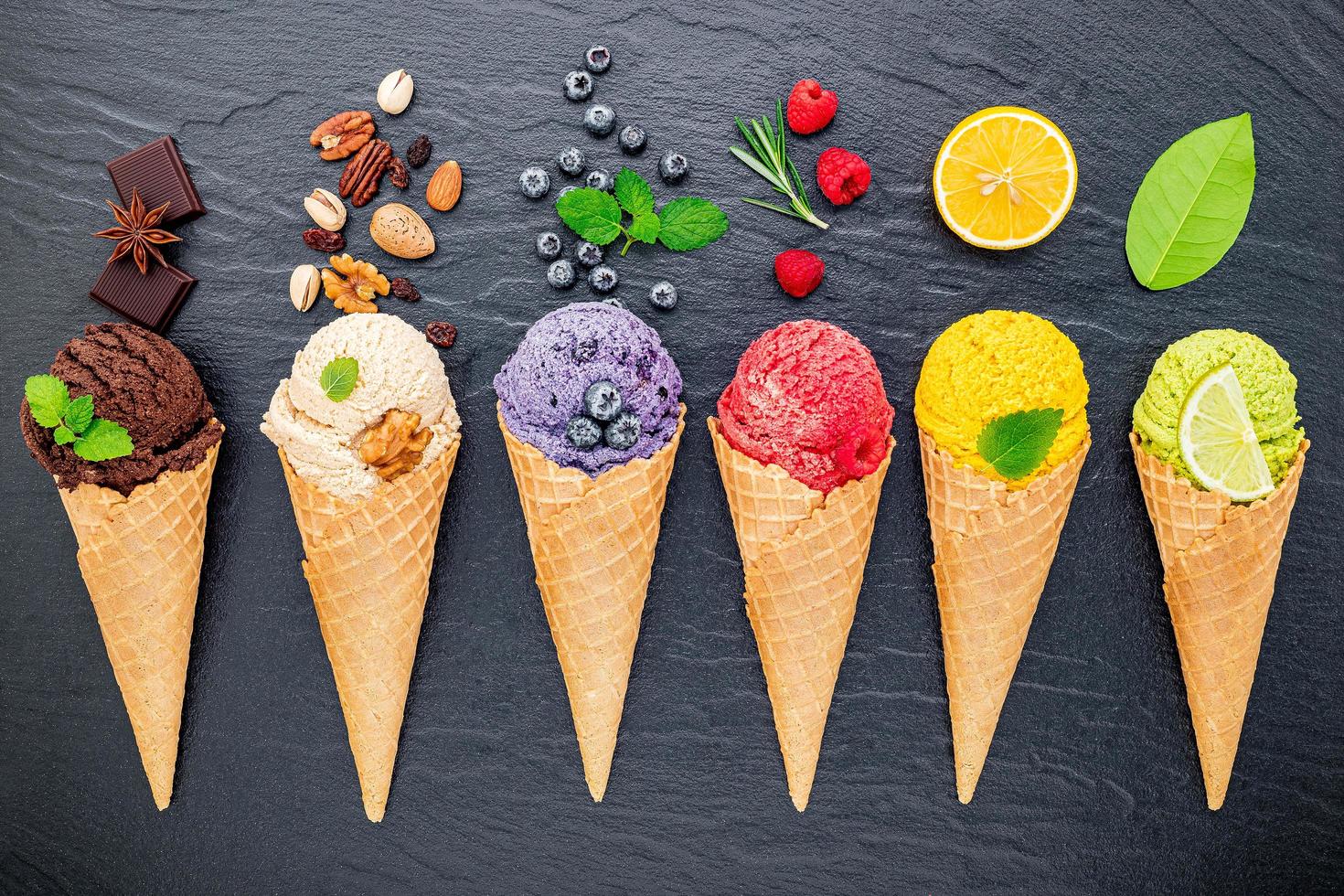 Various ice cream flavors in cones on a dark stone background. Summer and sweet menu concept. photo