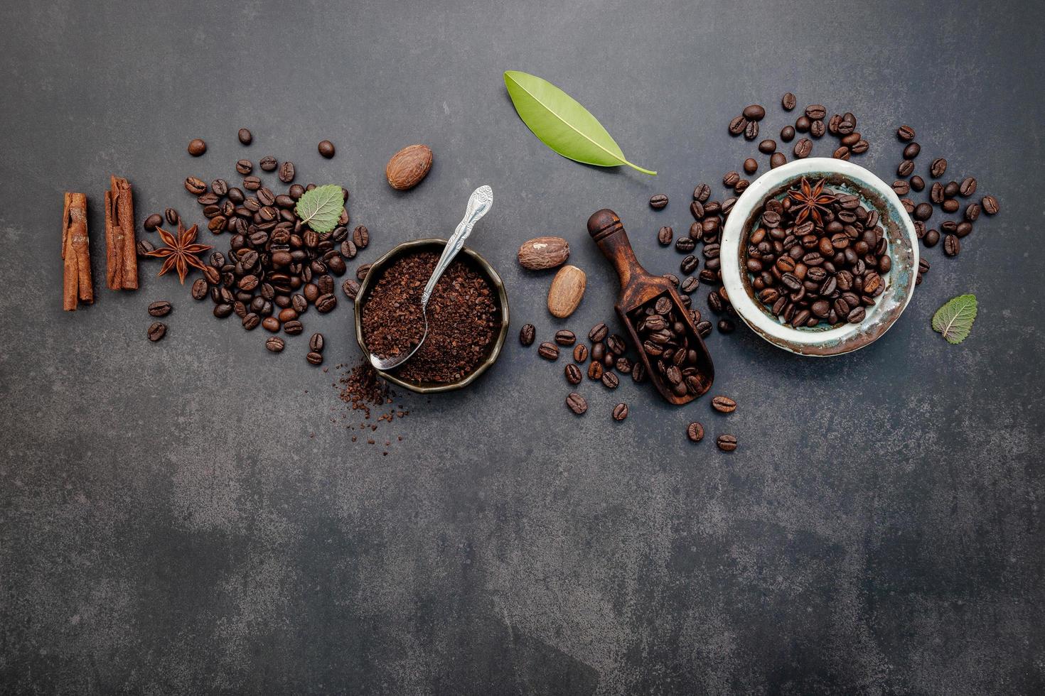 Granos de café tostados con café en polvo e ingredientes sabrosos para hacer café sobre un fondo de piedra oscura. foto