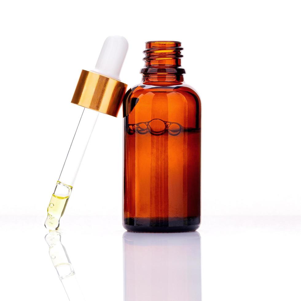 Essential oil bottles with dropper and bubbles isolated on a white background photo