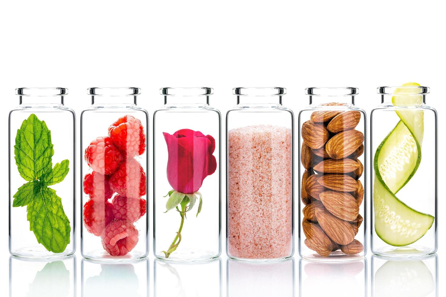 Cuidado de la piel casero con ingredientes naturales y hierbas en botellas de vidrio aislado sobre un fondo blanco. foto