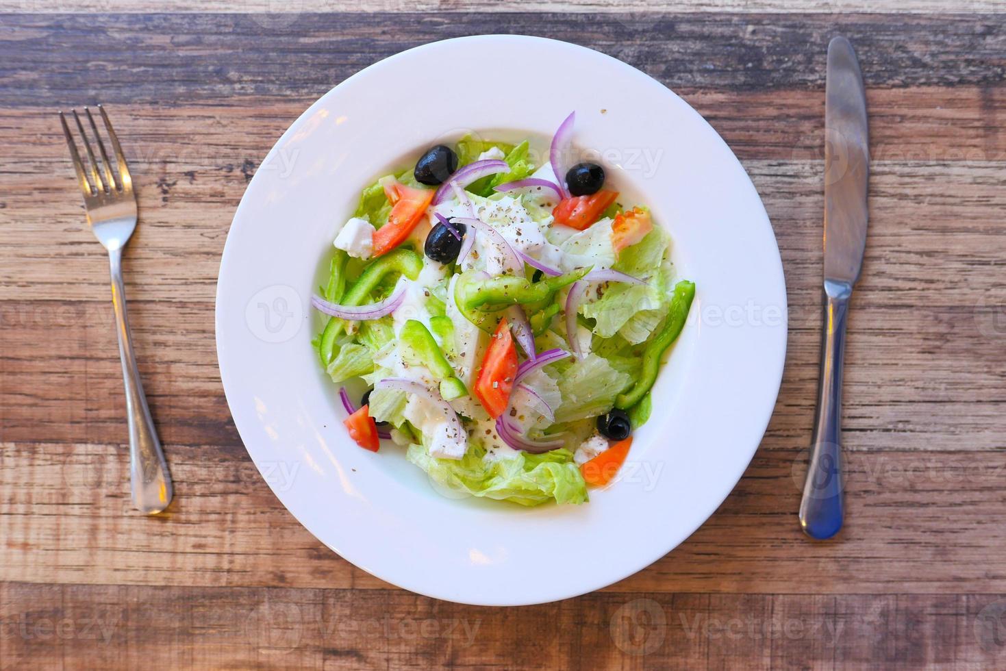 Top view of greek salad in a bowl on table photo