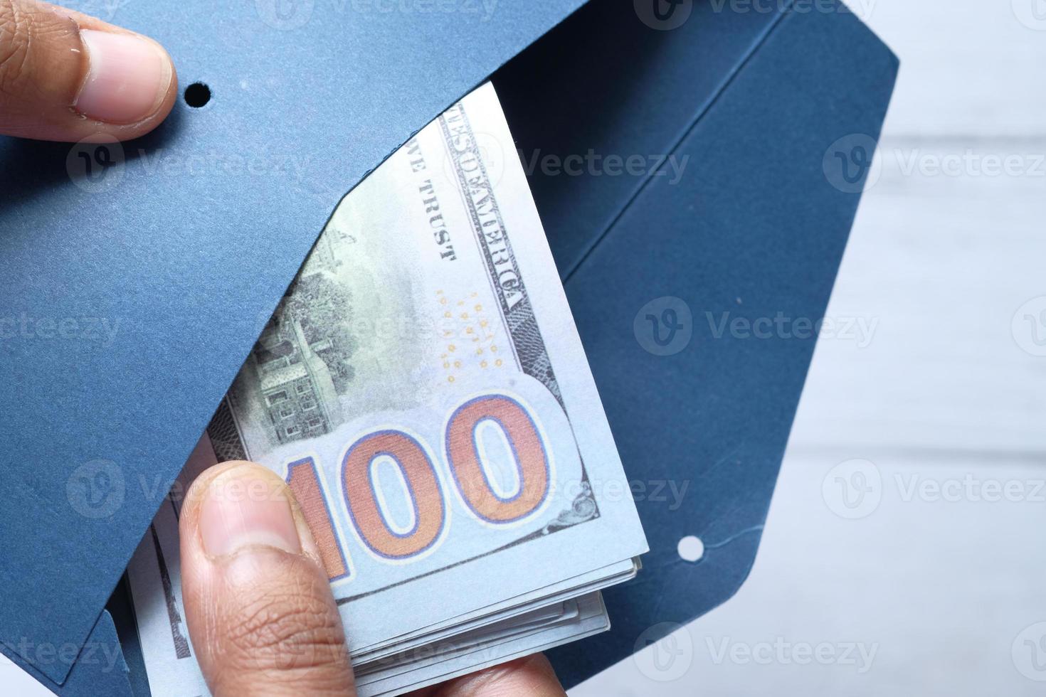 Person putting cash in an envelope photo