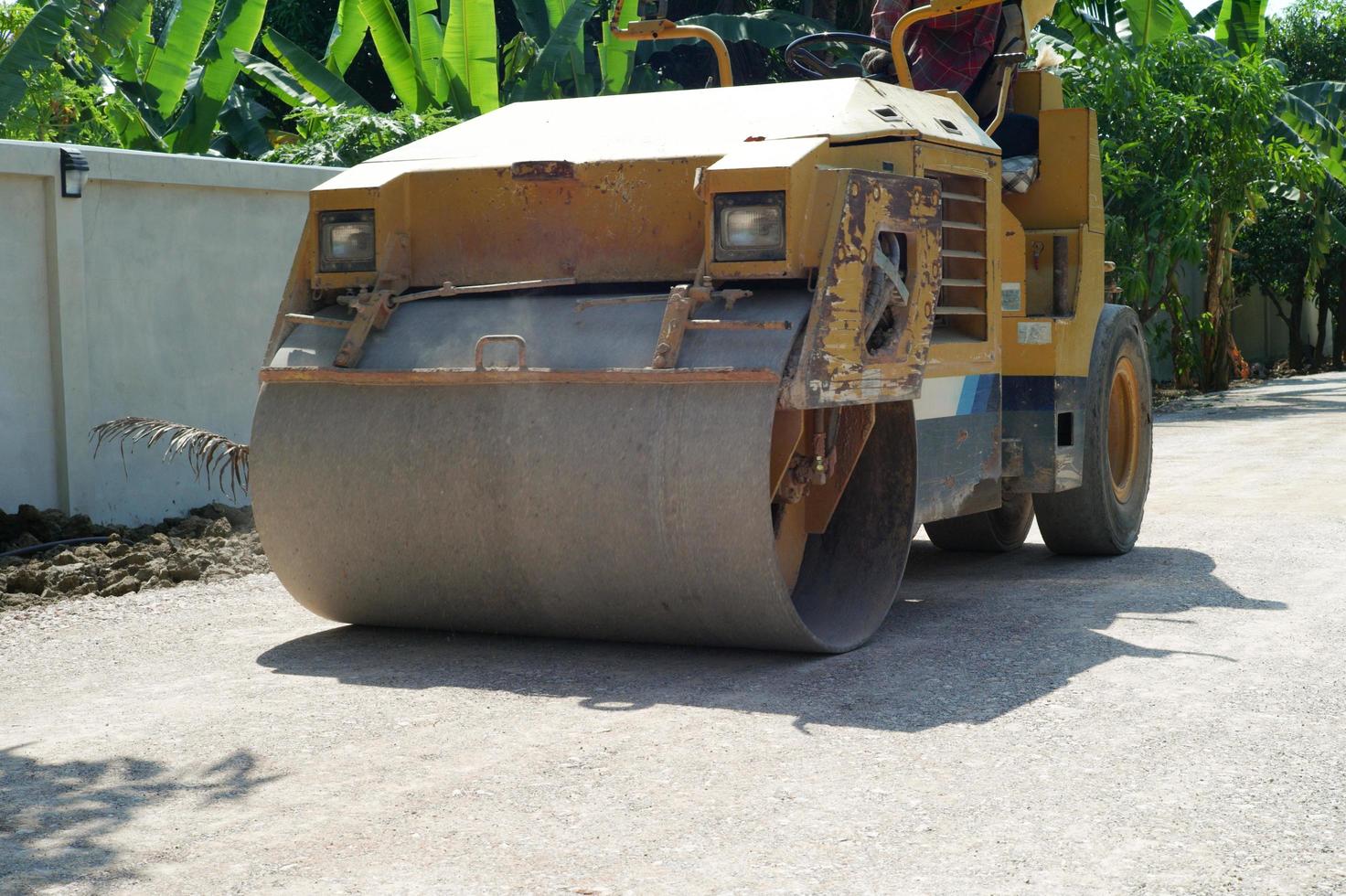 Heavy steel wheel of the road roller moving on the crash stone road under construction photo