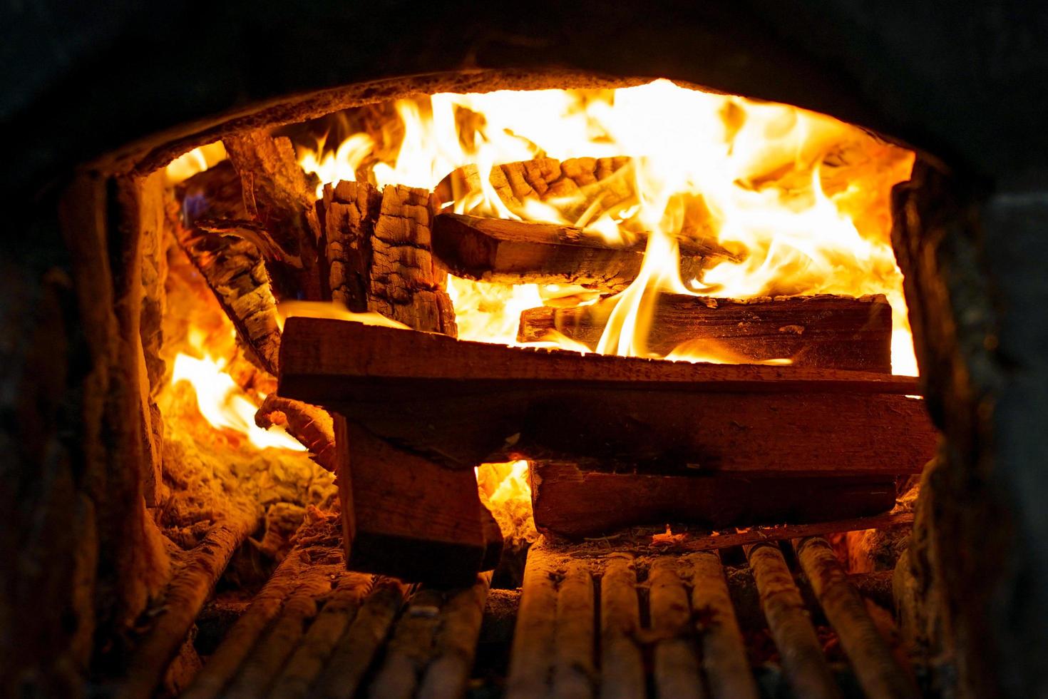 Close-up bulk of burning firewood in the traditional stove with ashtray photo