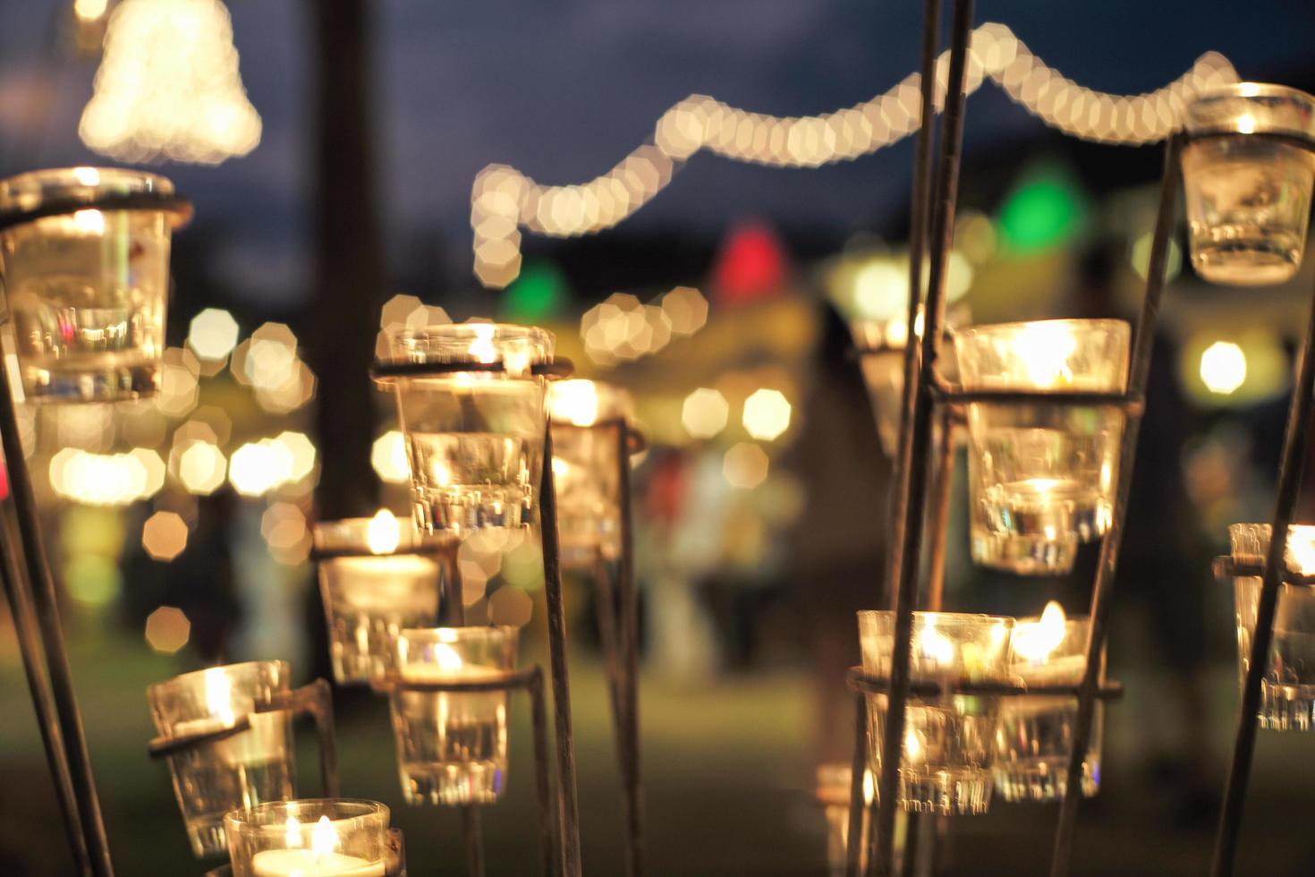 Selective focus on candles in small glasses with blurred bokeh lights in background photo