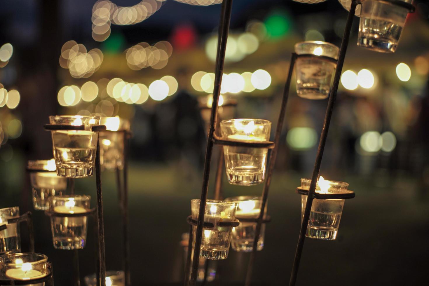 Selective focus on candles in small glasses with blurred bokeh lights in background photo