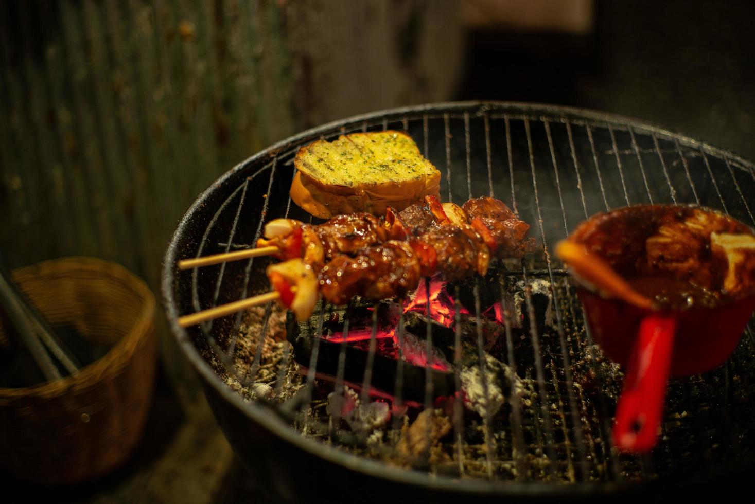 Imagen en primer plano de carne a la barbacoa y pan de ajo asado a la parrilla de carbón foto