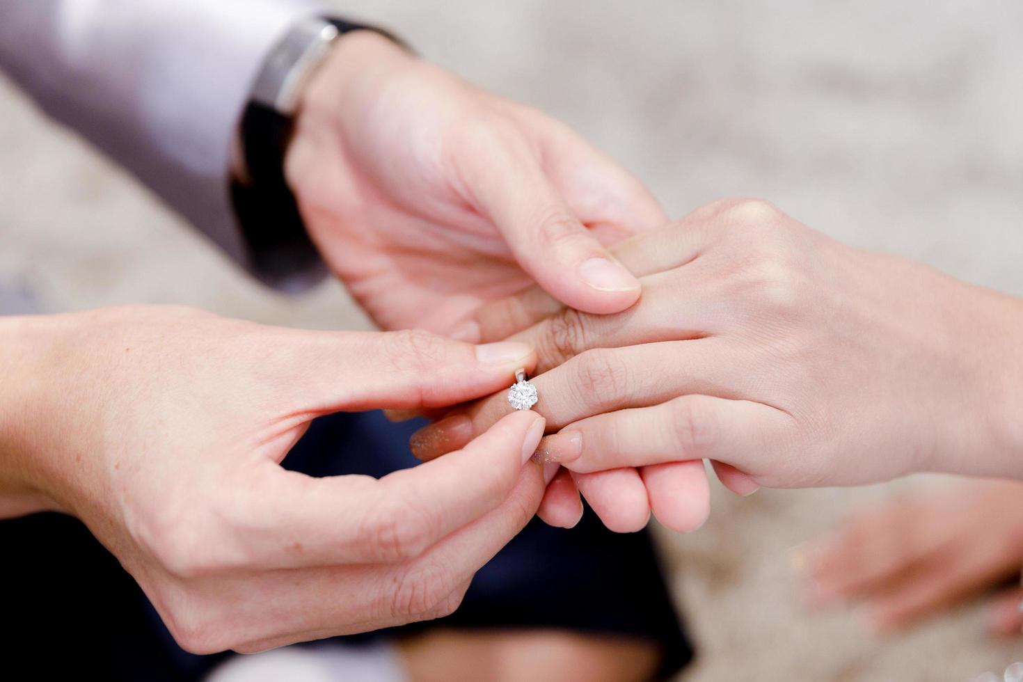 Closeup hands of groom and bride wearing wedding ring for ceremony photo