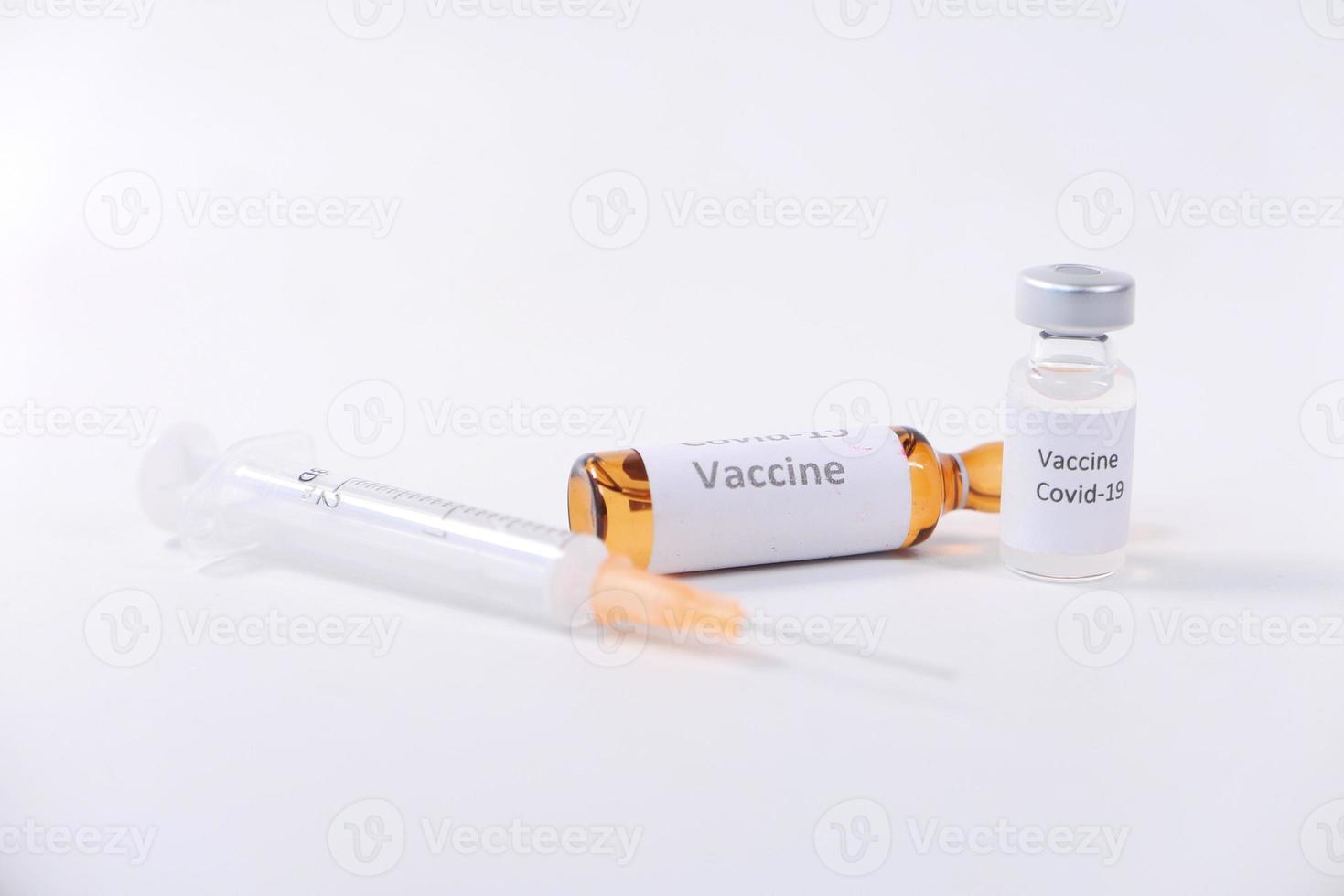 Cerca de la vacuna contra el coronavirus y una jeringa sobre fondo blanco. foto