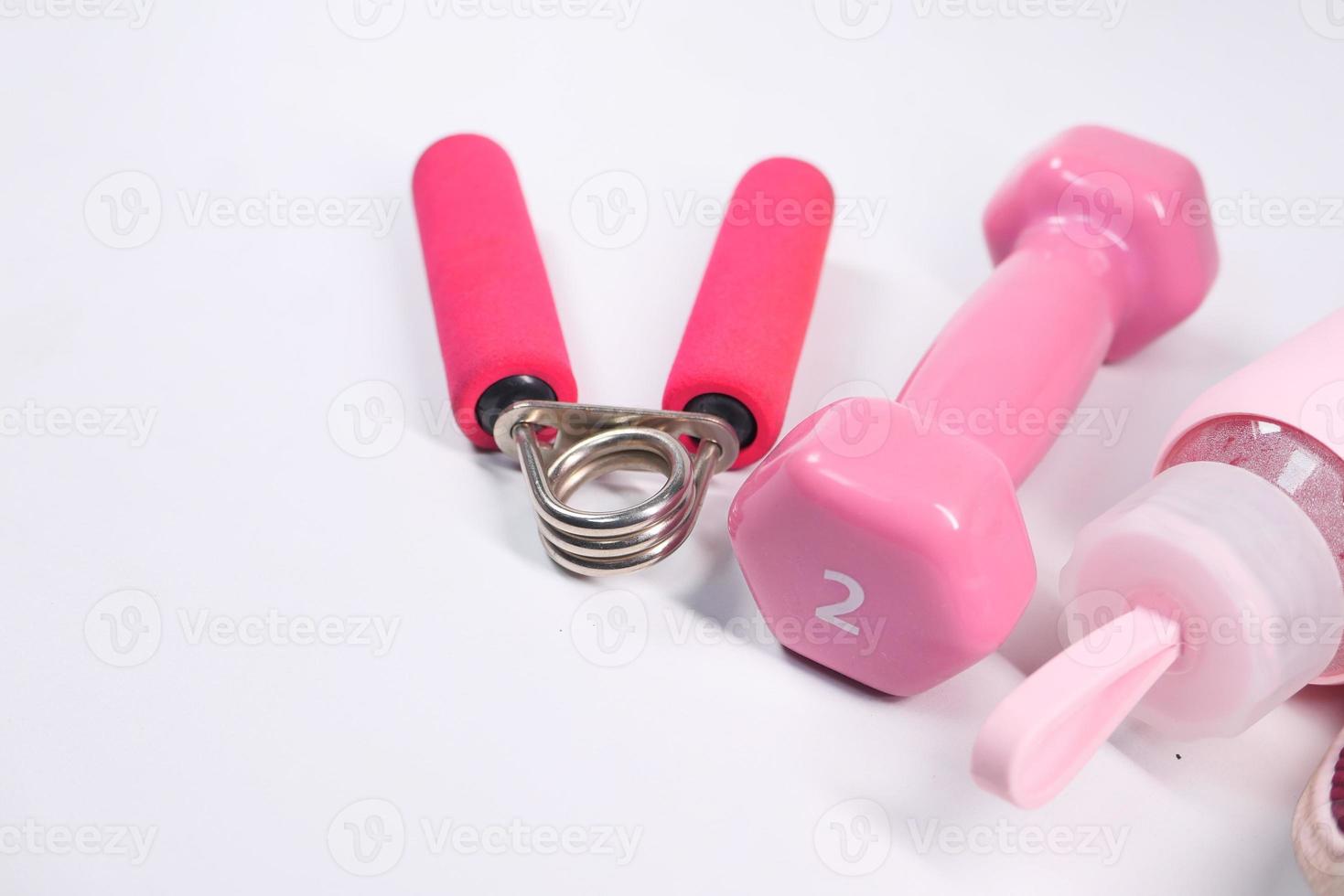Pink color dumbbell and water bottle on white background photo
