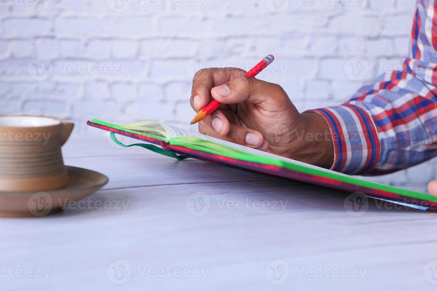 Close up of man hand writing on notepad photo