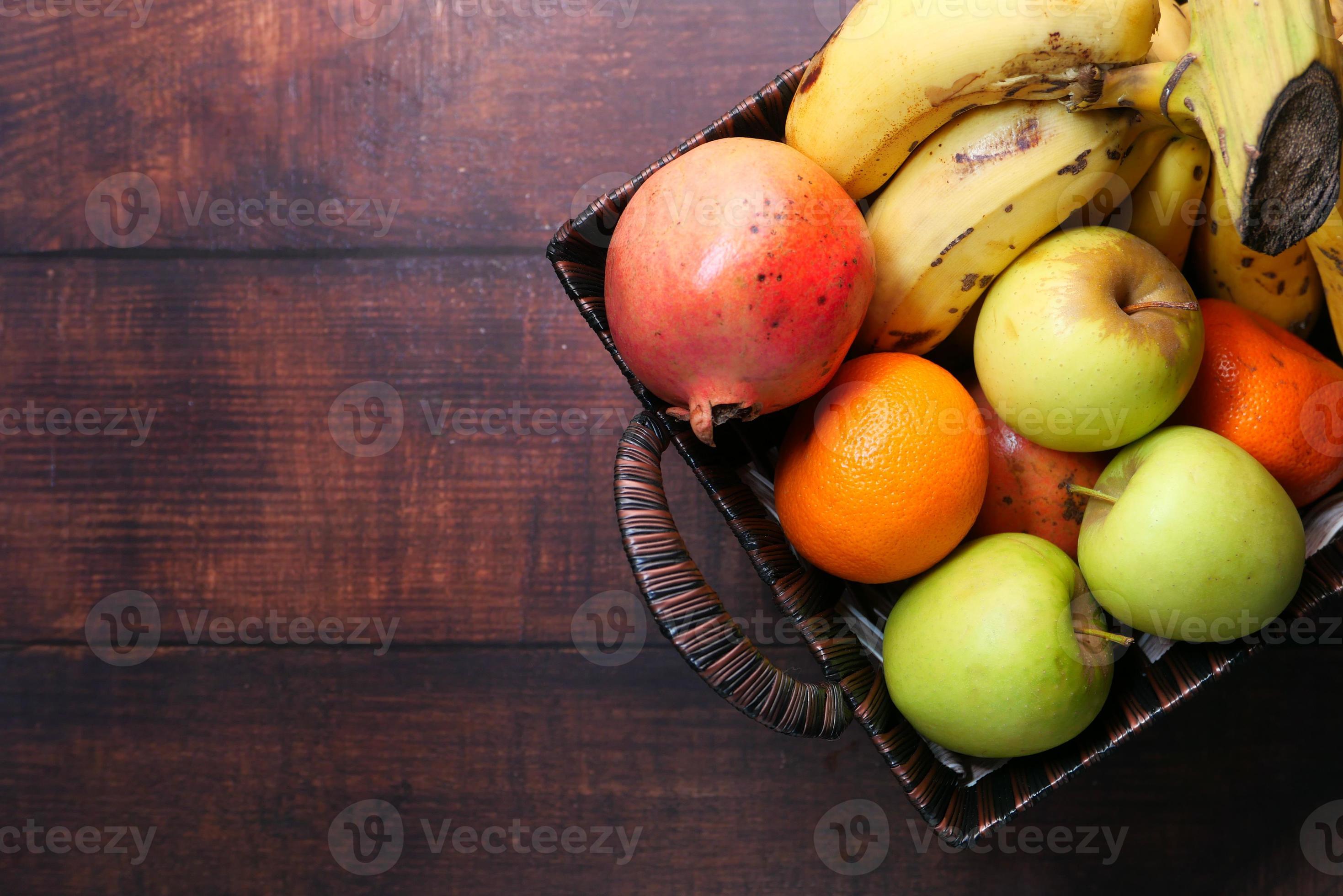 Top view of apples, bananas, and oranges in a bowl on table 2229489
