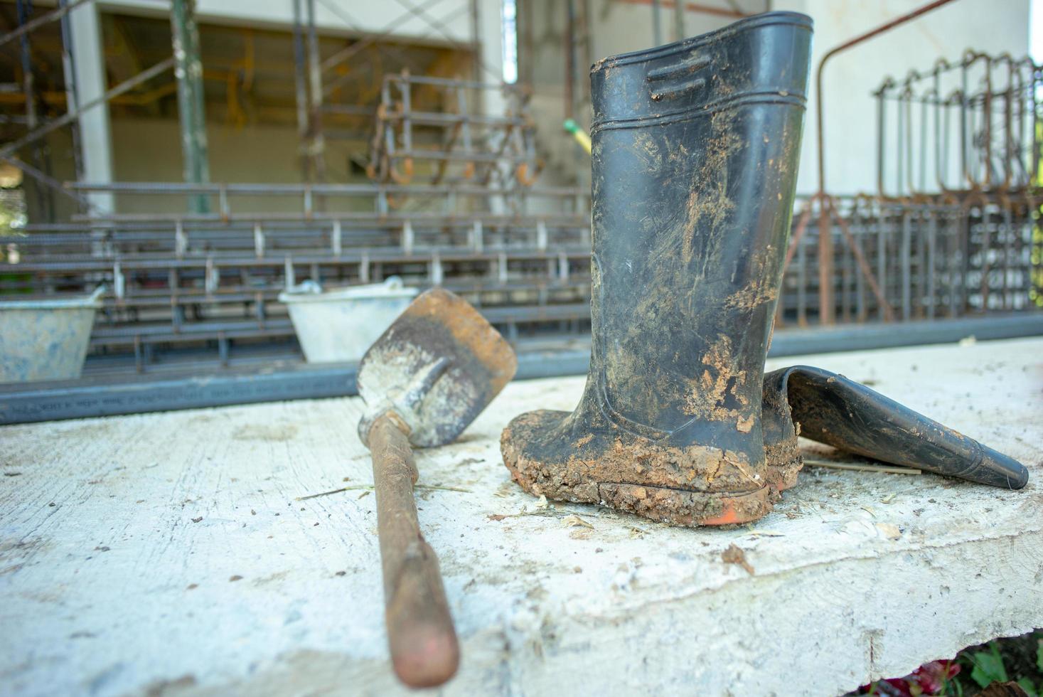 Closeup dirty rubber booths and hoe with blurred reinforcement steel photo