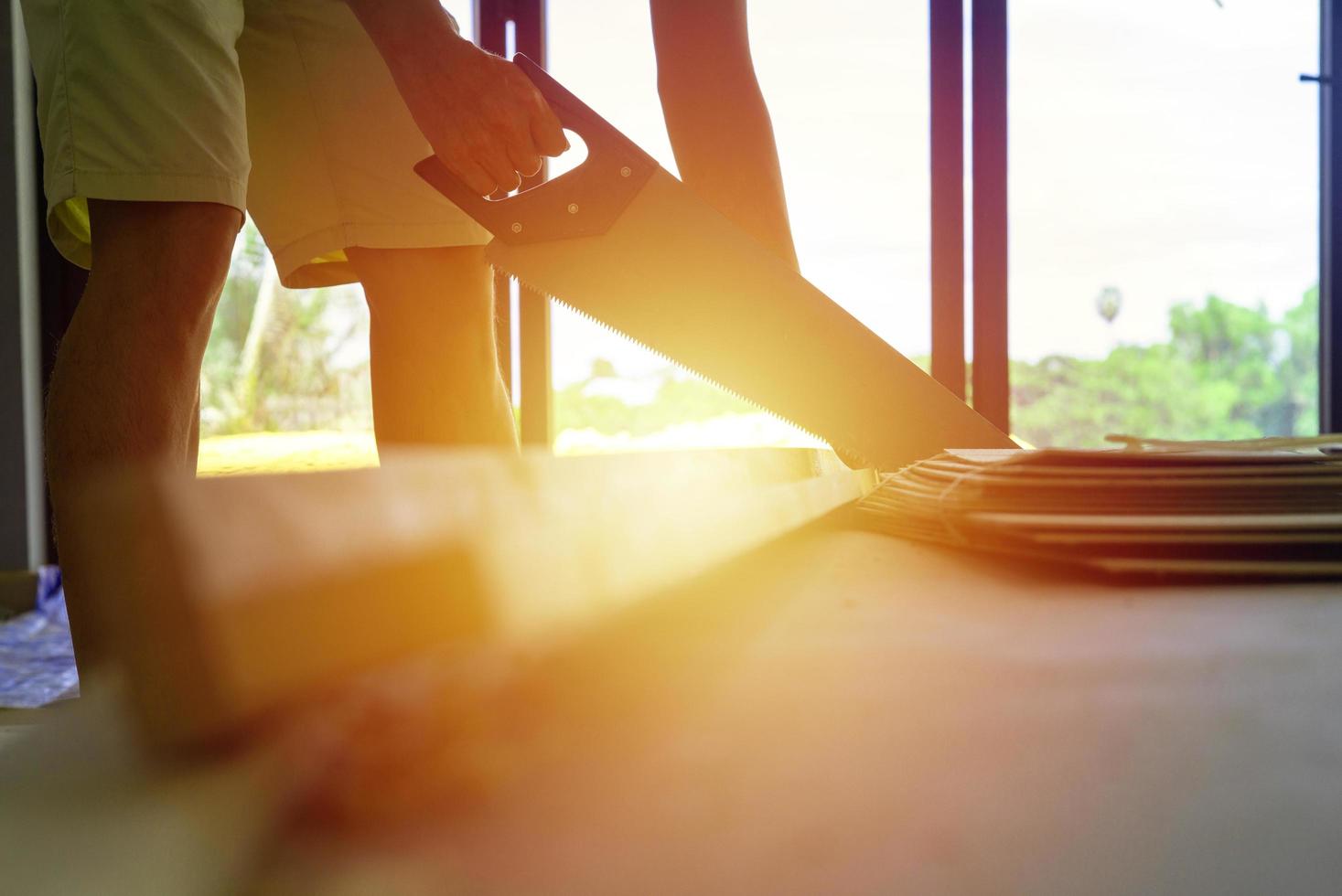 Primer plano de una persona con una sierra manual en casa en construcción foto