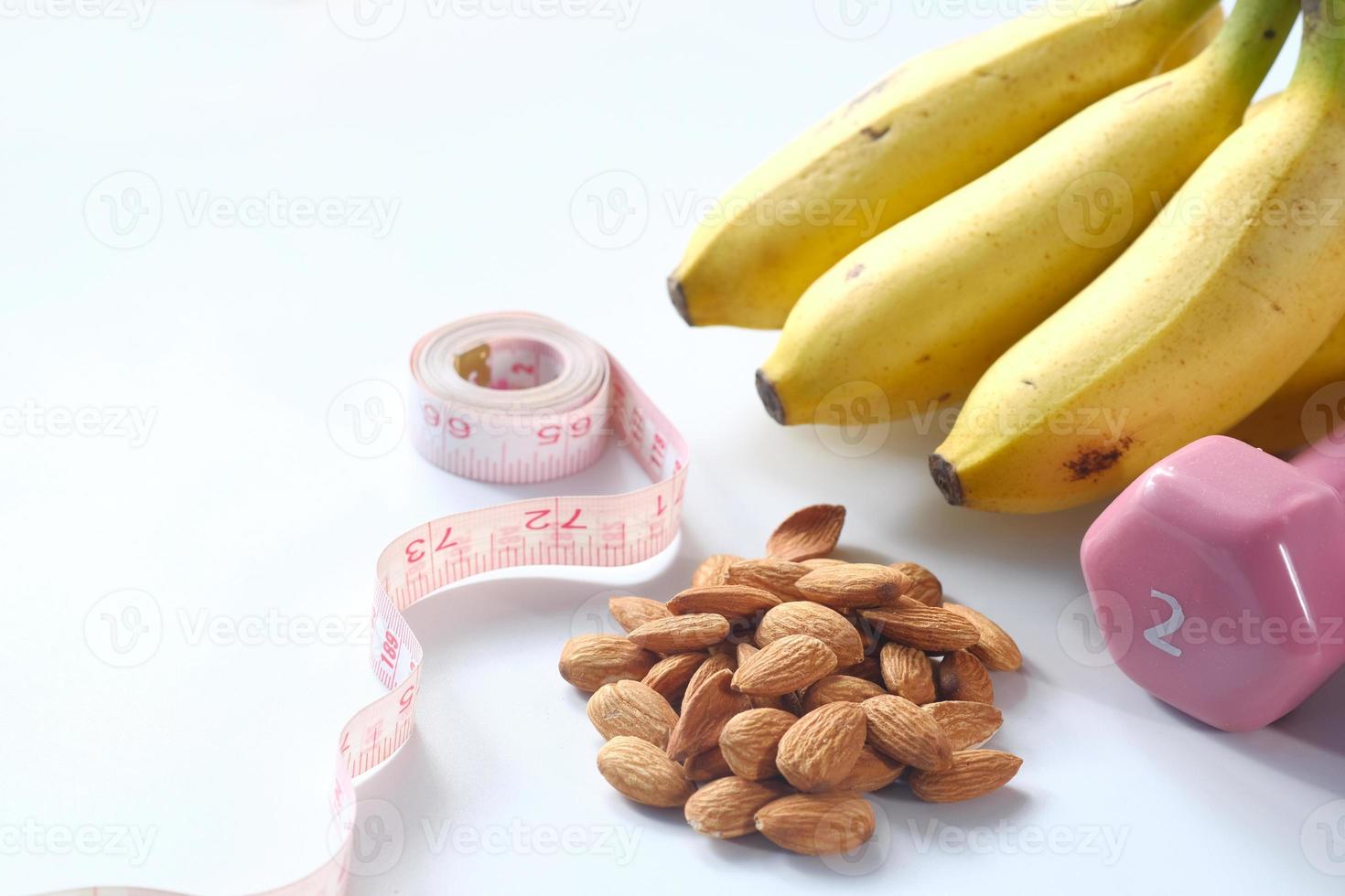 Diet plan with almonds, dumbbells, and banana on table photo