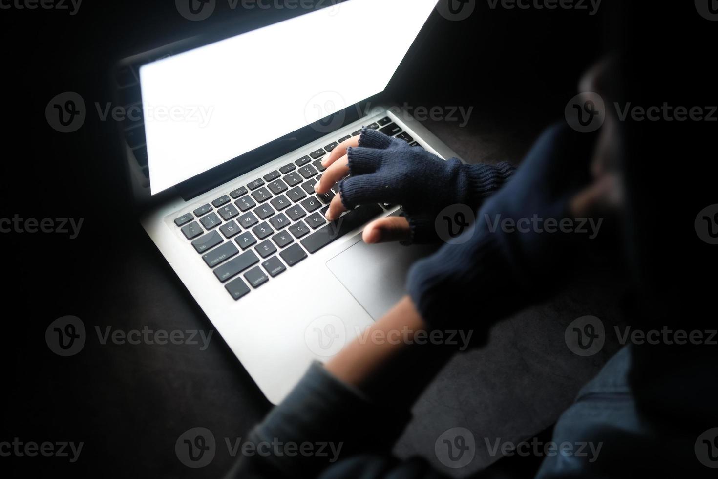 Hand typing on computer keyboard in the dark photo