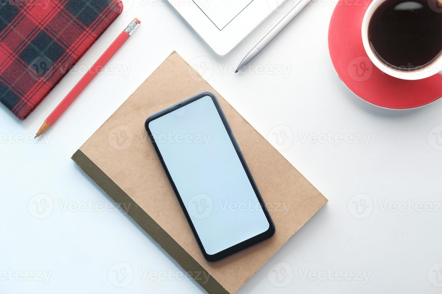 Top view of smart phone and notepad on table photo