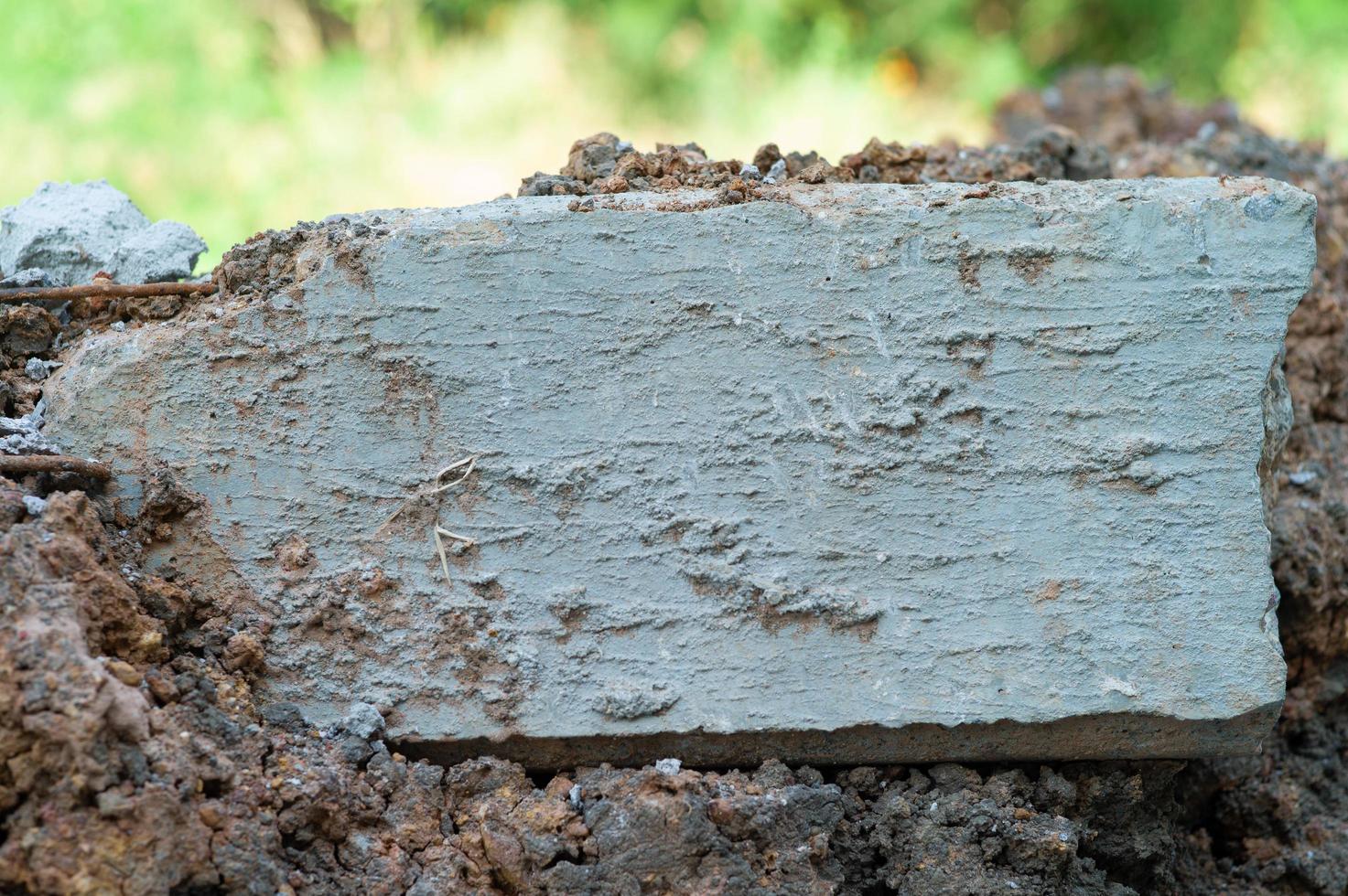 Closeup broken concrete structure with reinforcement steel lay on the soil ground photo