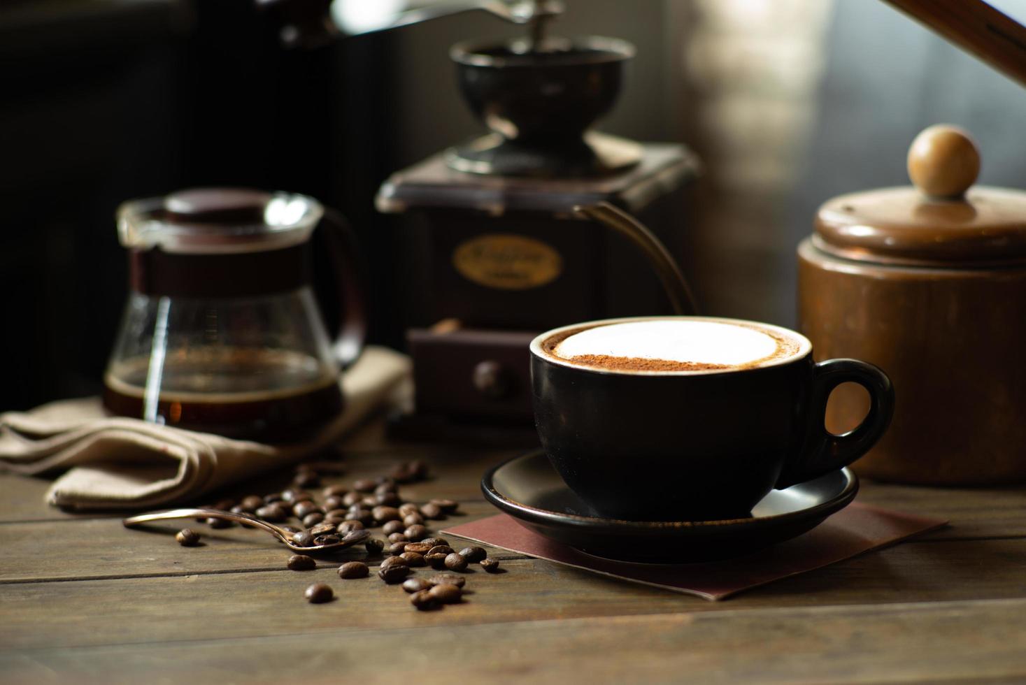 Café y té en la mesa con enfoque selectivo en taza de capuchino y frijoles foto