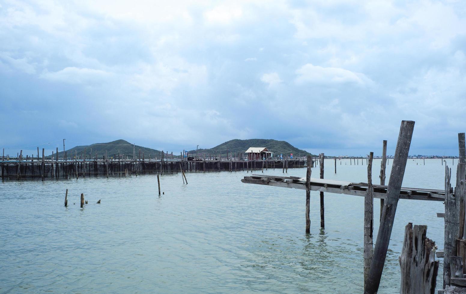 Native fisherman house and traditional fishing farm at the coast of sea with old wooden walkway photo