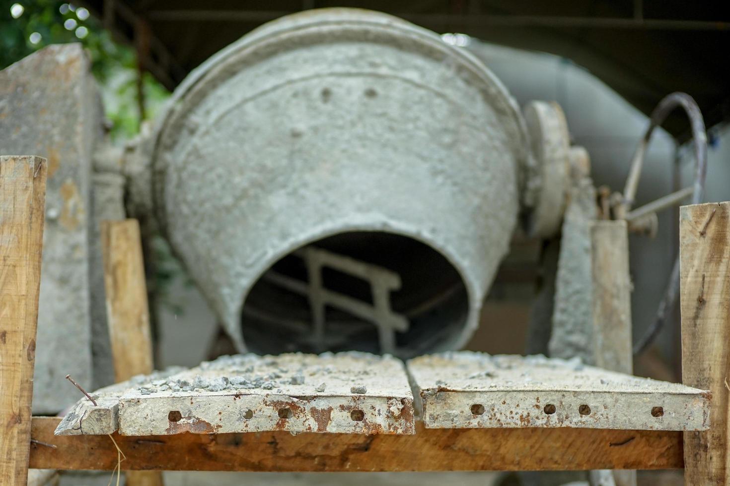 Selective focus on group of crashed stones on the steel plate with blurred concrete mixer photo