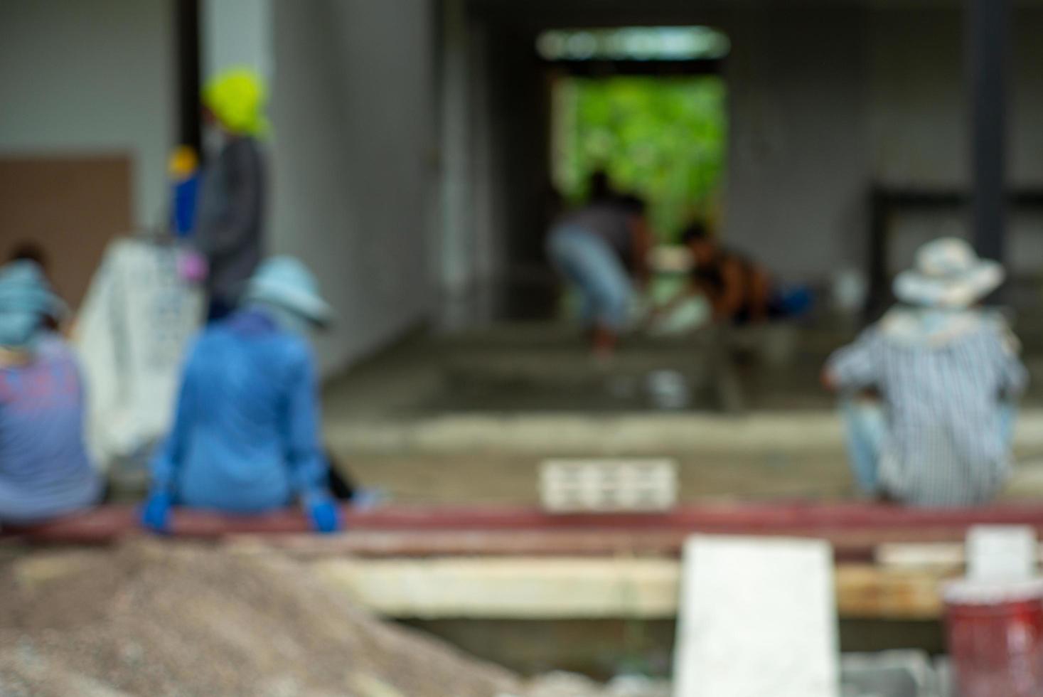 Defocused ground of workers work at the house under construction photo