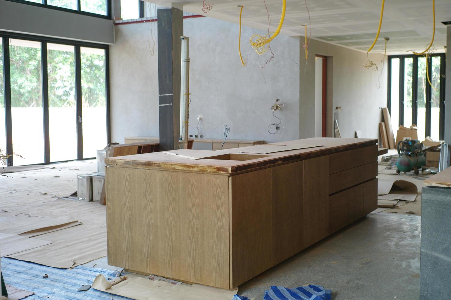 Selective focus on wooden kitchen island under installation in the house under construction photo